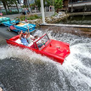 Red Amphicar splashing into the water